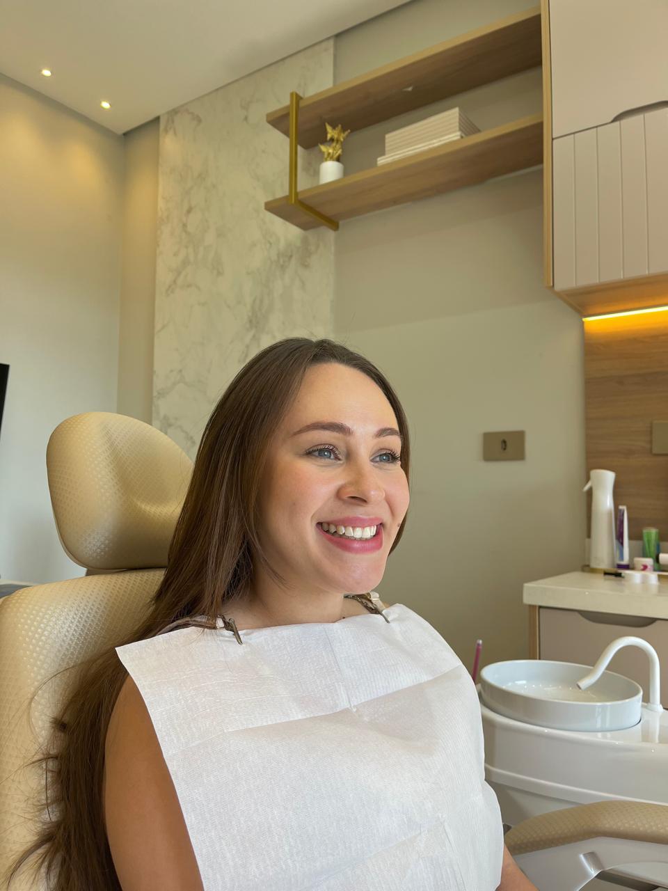 Paciente sorrindo no consultório após atendimento